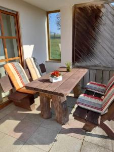 a wooden table and chairs on a patio at Ferienwohnung Tor zum Oberwald in Herbstein
