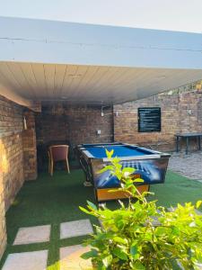 a ping pong table in a room with a brick wall at Ojong's Self Catering Accommodation Bellville in Cape Town