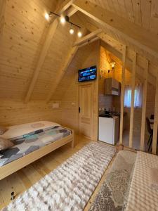 a log cabin bedroom with a bed and a kitchen at KOMOVI - Dream house - 2 in Andrijevica
