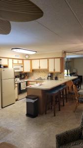 a kitchen with a refrigerator and a table with chairs at 210 Worcester St #203 OC in Ocean City