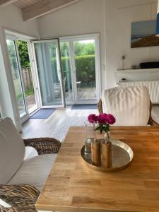 a living room with a table with a vase of flowers at Schleihaus Lorenz mit Feldblick in Boren +44 photos