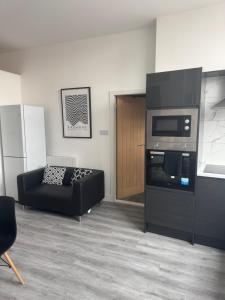 a living room with a couch and a stove at Stylish modern 2 bedroom flat 6B in Denton +14 photos
