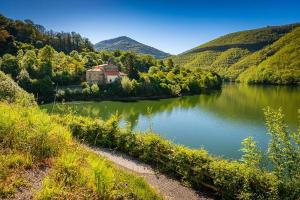 a river with a house in the middle of a valley at R2R - Casa Arbys - 36A01 in Pola de Laviana