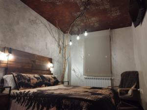 a bedroom with a bed and a tree on the wall at Paraíso Desconocido 1. Pura Magia in Cardaño de Abajo