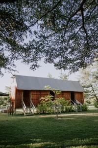 a wooden barn with a metal roof on a field at Muchenje River Lodge in Katima Mulilo