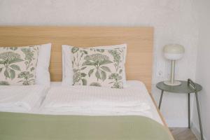 a bed with a wooden headboard and two pillows at Well M cottage in Velem