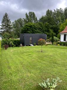 a small black house in a yard at Le Lodge de la Course in Beussent