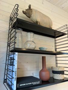 a shelf with a vase and other items on it at Le Lodge de la Course in Beussent