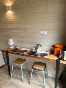 a wooden table with two chairs in a room at Le Lodge de la Course in Beussent