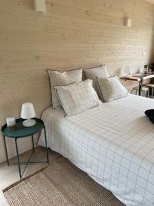 a bedroom with a white bed and a table at Le Lodge de la Course in Beussent