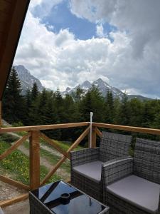 a balcony with two chairs and a table and mountains at KOMOVI - Dream house - 2 in Andrijevica +5 photos
