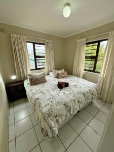 a bedroom with a bed in a room with windows at Serengeti Heide Self Catering Flats in Cape Town