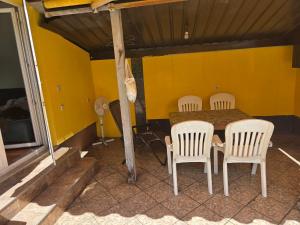 a table and chairs in a room with a yellow wall at Le Solei Apartment in Visoko