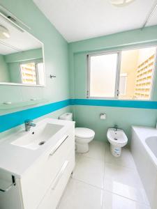 a bathroom with a sink and a toilet and a mirror at Apartamento Benidorm primera linea in Benidorm