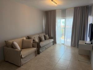 a living room with a couch and a large window at Newly renovated- Regina Gardens 1, Venus Beach 500 m, Sea&Sunsets view, license oo12075 in Paphos