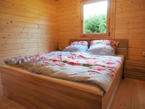 Bett in einem Blockhaus mit Fenster in der Unterkunft Ferienhaus Holzhaisl in Kelheim