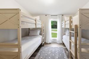 two bunk beds in a room with a window at Cozy Haven in Three Oaks