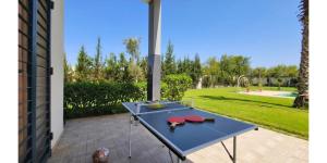 a blue table on a patio with a garden at L'Oasis in Mzerguia