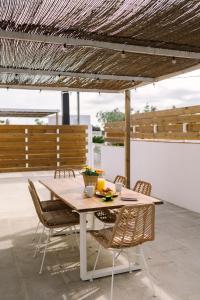 a wooden table and chairs on a patio at Masia CHOPO in L'Aldea
