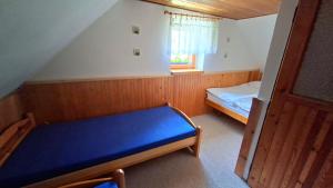a small bedroom with a bed and a window at Chalupa U Potoka Javorna in Javorná