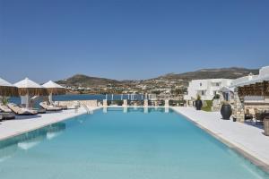 a large swimming pool with chairs and umbrellas at Pounda Resort Paros, a member of Radisson Individuals in Pounda