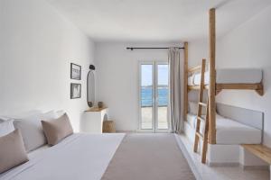 a white bedroom with a bunk bed and a window at Pounda Resort Paros, a member of Radisson Individuals in Pounda +41 photos