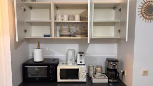 a kitchen with a microwave and a coffee maker at Studio à Sainte-Marie Studio Calme-Bord de mer avec Piscine in Sainte-Marie