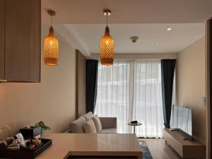a living room with two hanging lights and a couch at Laya Suites and Residences in Bang Tao Beach