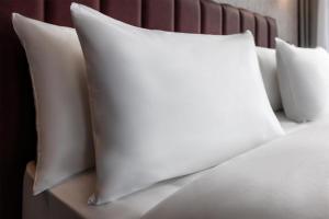 a pile of white pillows on a bed at Radisson Hotel Berlin Charlottenburg in Berlin +20 photos