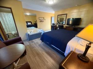 a hotel room with a bed and a television at Sunset Inn in Niagara Falls