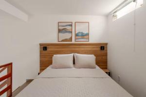 a bedroom with a bed with two pillows at Villa Bela - Lofts - cama queen e ar-condicionado in Iguaba Grande