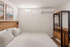 a bedroom with a bed and a glass shower at Villa Bela - Lofts - cama queen e ar-condicionado in Iguaba Grande +1 photo