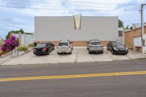a group of three cars parked in a parking lot at Villa Bela - Lofts - cama queen e ar-condicionado in Iguaba Grande