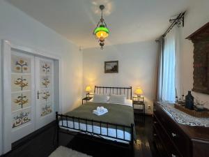 a bedroom with a bed and a chandelier at Casa Alexandra Slătineanu in Bran