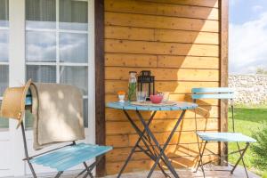 a table and two chairs on a patio at Le Bois aux Cerfs in Bois-Jérôme-Saint-Ouen