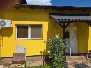 a yellow house with a black roof at Le Solei Apartment in Visoko