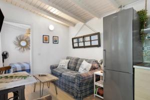 a living room with a couch and a refrigerator at Tiny House La Loma in Barbate