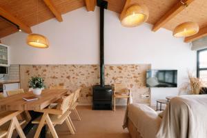 a living room with a wooden table and a stove at Masia CHOPO in L'Aldea