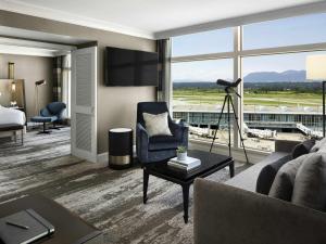 a living room with a couch and a television in a hotel room at Fairmont Vancouver Airport In-Terminal Hotel in Richmond