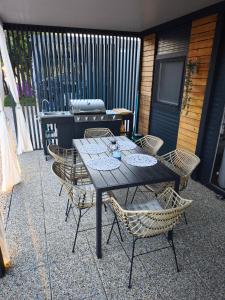 a table and chairs on a patio with a grill at Rilux Mobile Home "Camping Pirovac" in Pirovac