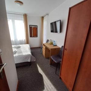 a bedroom with a bed and a desk and a television at Akwen in Rewal