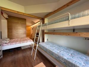 a bedroom with two bunk beds and a ladder at Rifugio Artuik 1400 in Marilleva