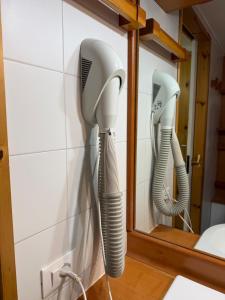 two hairdryers hanging on a wall in a bathroom at Rifugio Artuik 1400 in Marilleva