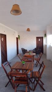 a group of wooden tables and chairs in a room at hospedaria Cantinho da Rosa in Santo Amaro