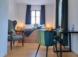 a room with a bed and a table and chairs at Hotel Bezold in Rothenburg ob der Tauber