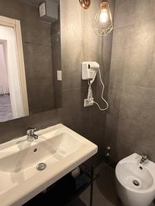 a bathroom with a sink and a mirror and a toilet at Residence e appartamenti Bausan in Naples +16 photos