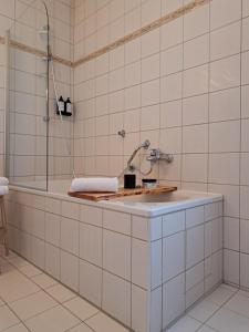 a bathroom with a bath tub with a sink at Hotel Bezold in Rothenburg ob der Tauber