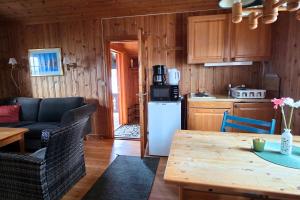 a kitchen and living room with a table and a refrigerator at Odin Camping AS in Svensrud +18 photos
