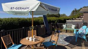 a table and chairs under an umbrella on a patio at 4 Meadow View in Woolacombe