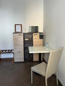 a table and a chair in a room with a microwave at Pasa da sí in Alba